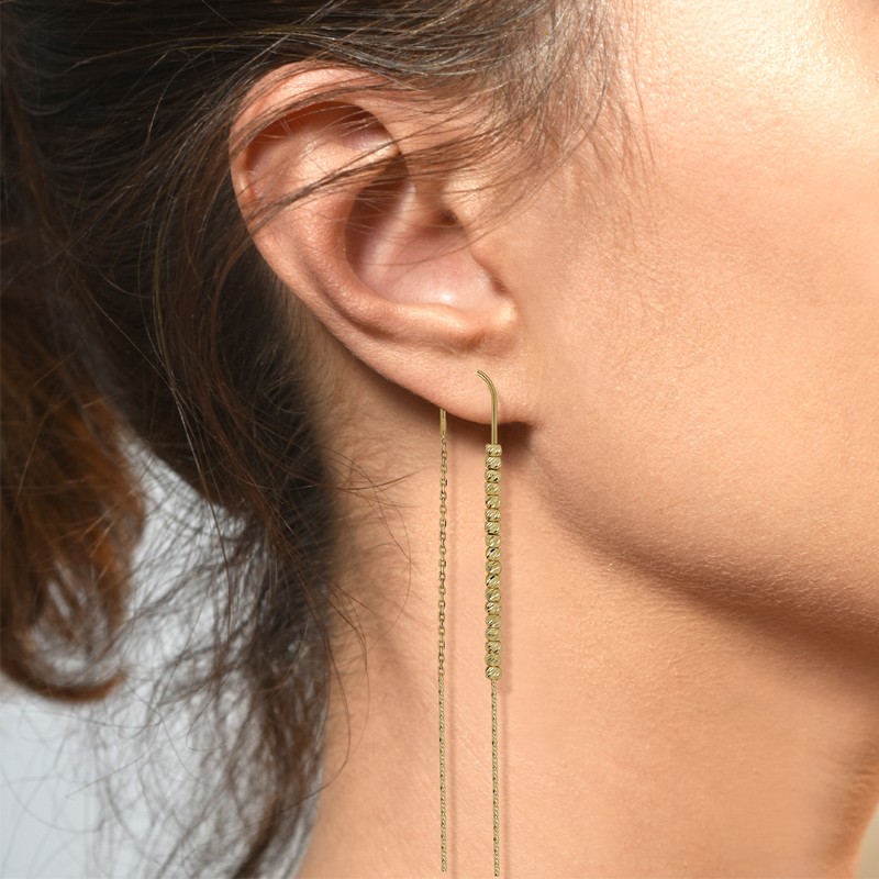 złote Kolczyki przewlekane o splocie Ankier na uchu